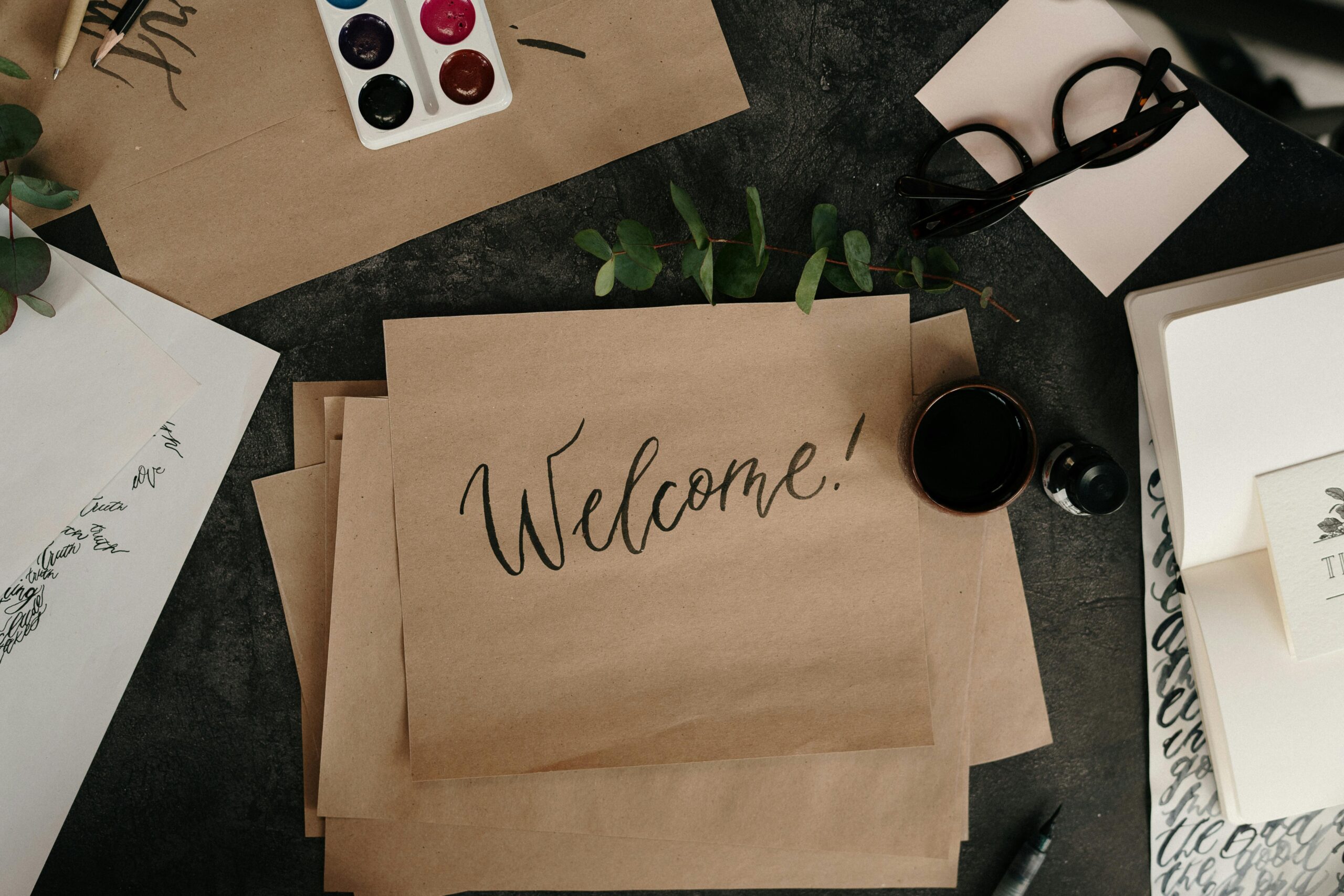 Welcome to "Seasons of Change"- the official TBB Blog! A creative workspace featuring calligraphy, envelopes, and art supplies for crafting personalized welcome cards.